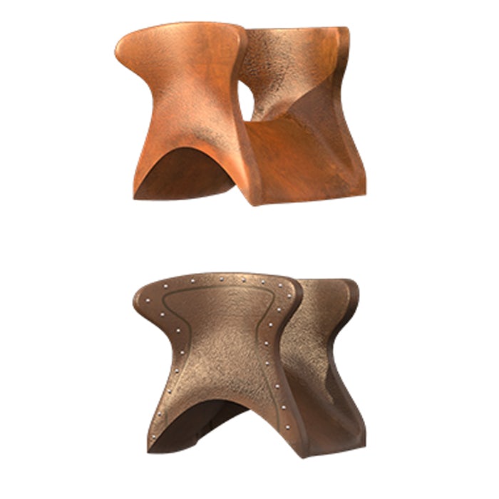 Two medieval saddles are displayed, one over the other. The saddle at the top is made from a polished, light wood. The saddle underneath has a leather cover, attached by rivets along the edges.
